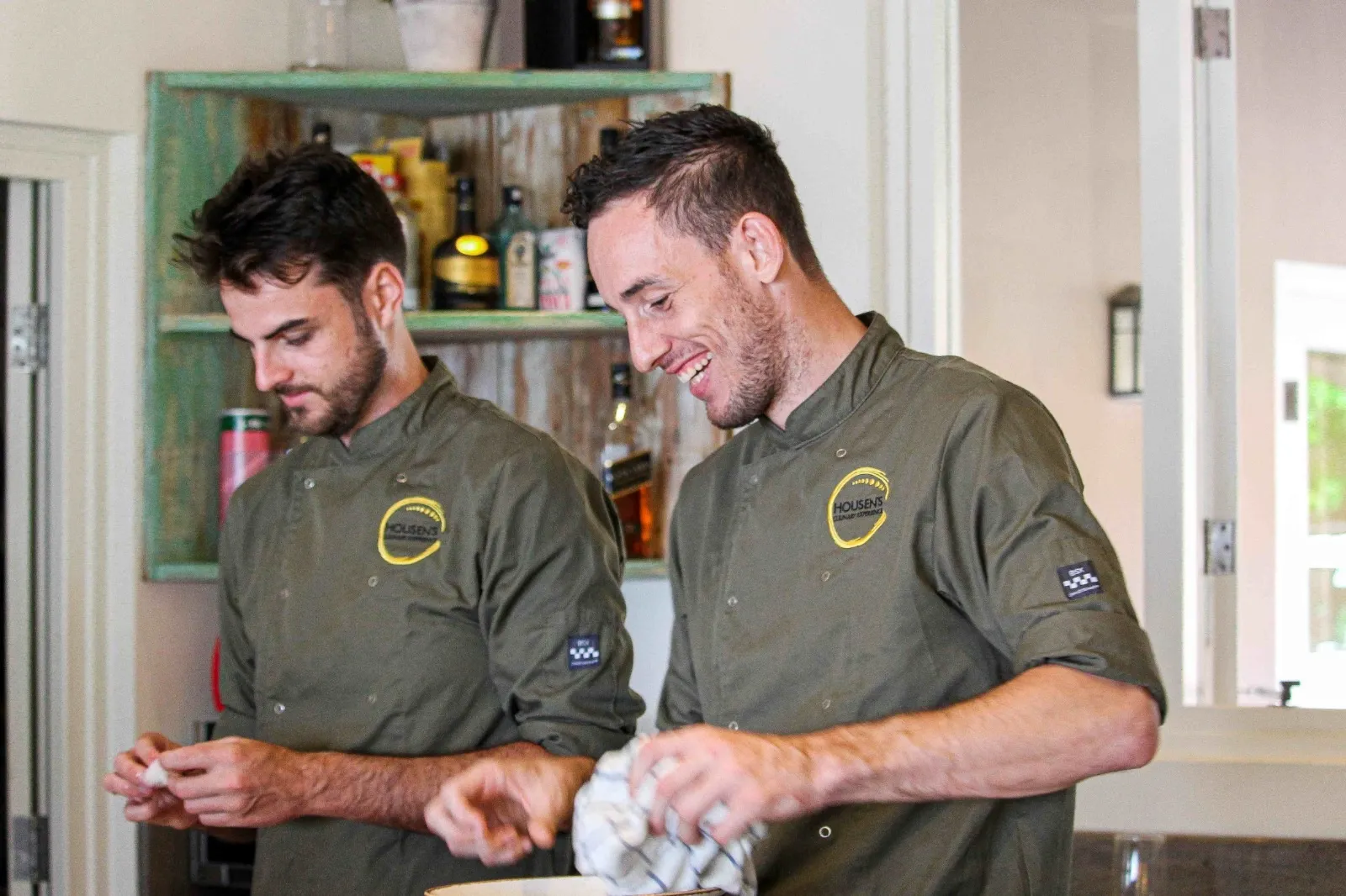 Chef Robin Housen sharing a laugh with a colleague in the kitchen