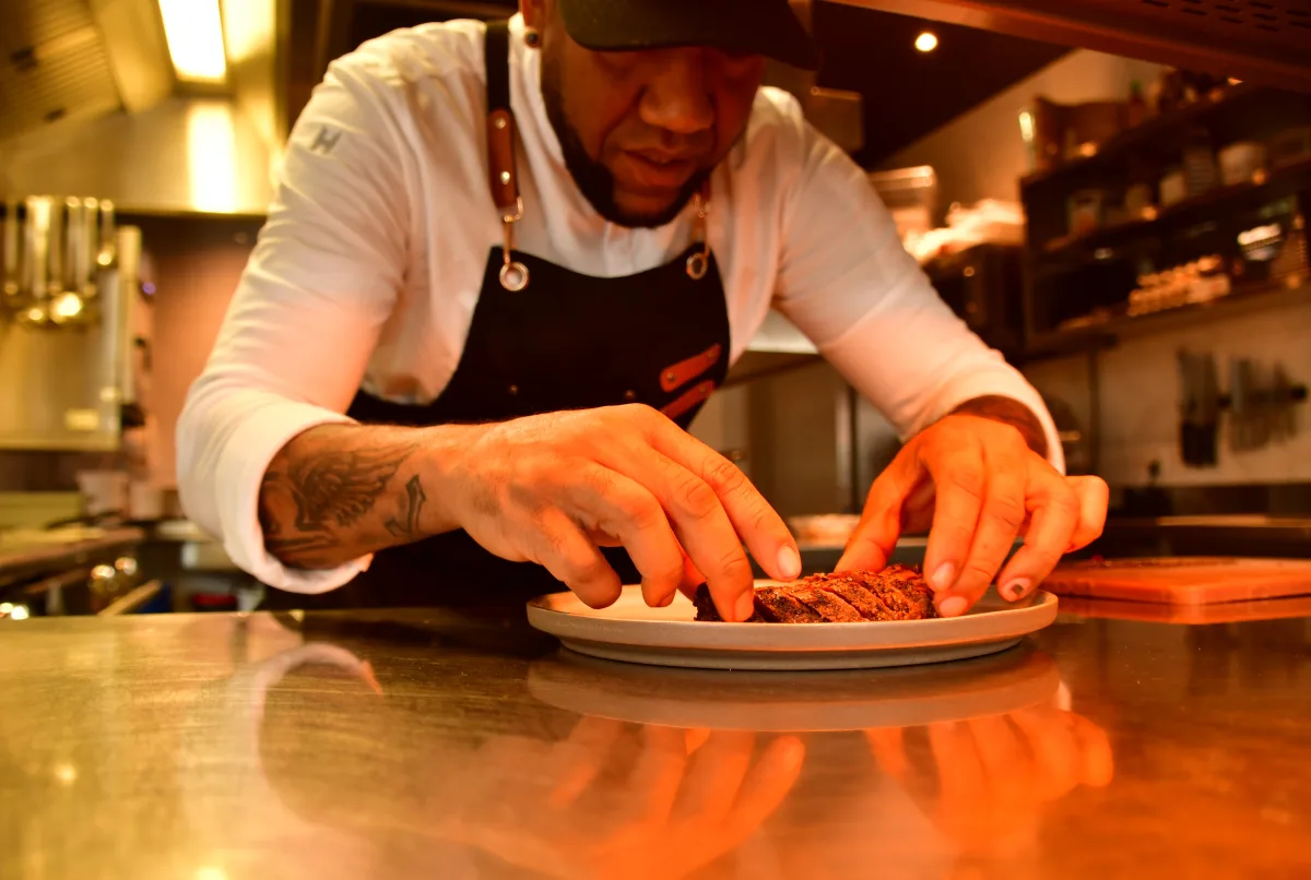 Chef Wilmar Raphaela plating a dish in the kitchen